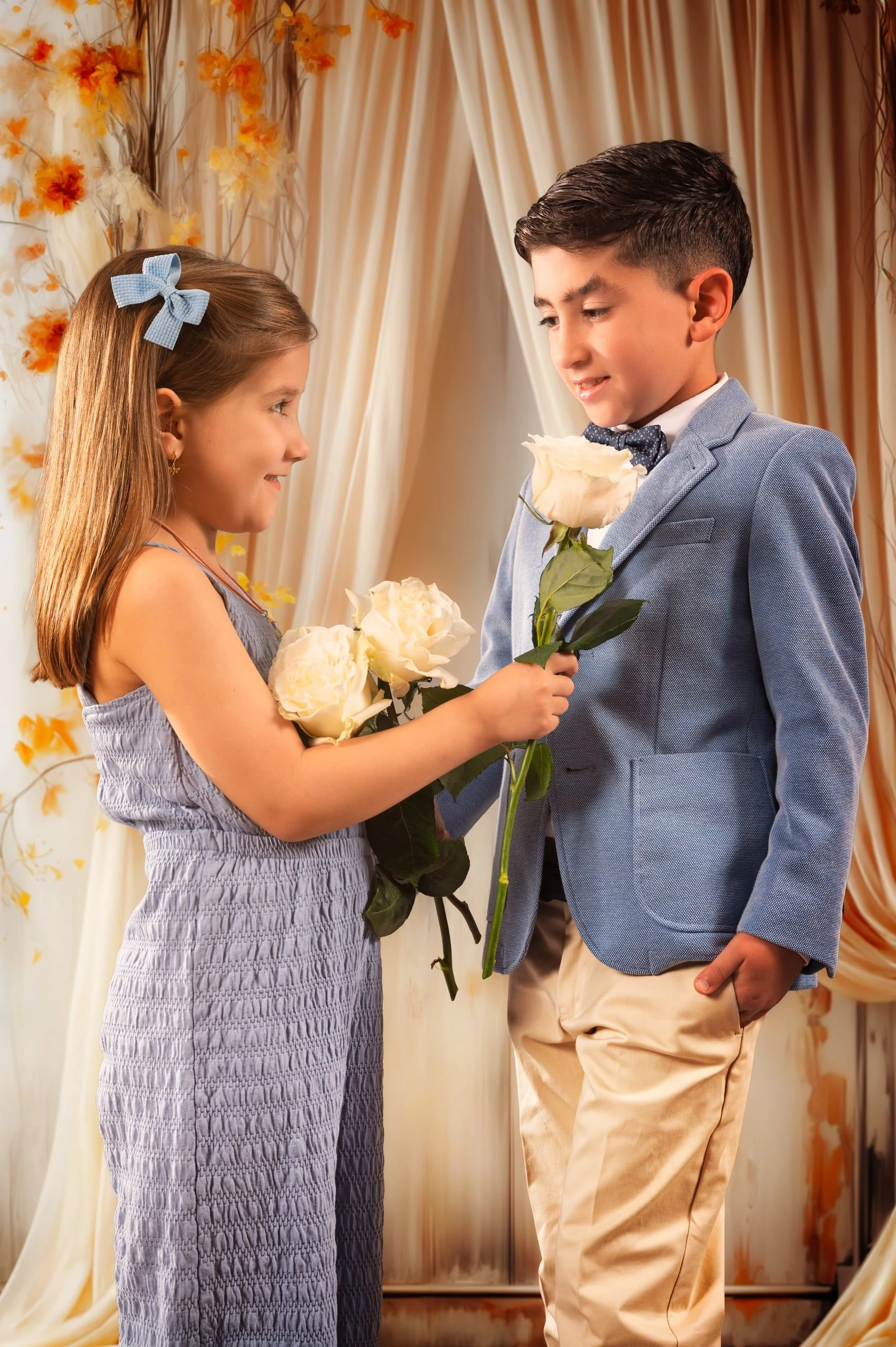 Hermana y hermano compartiendo una flor durante un retrato de comunión.