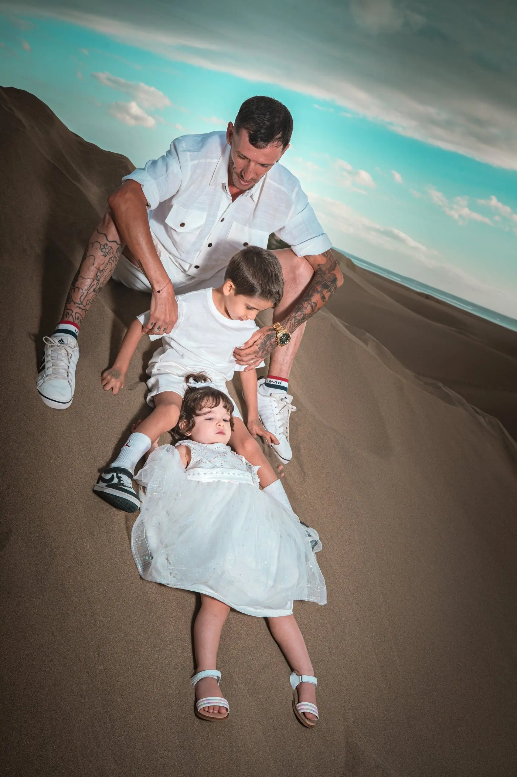 Padre y su hija pequeña juegan juntos sobre la arena.
