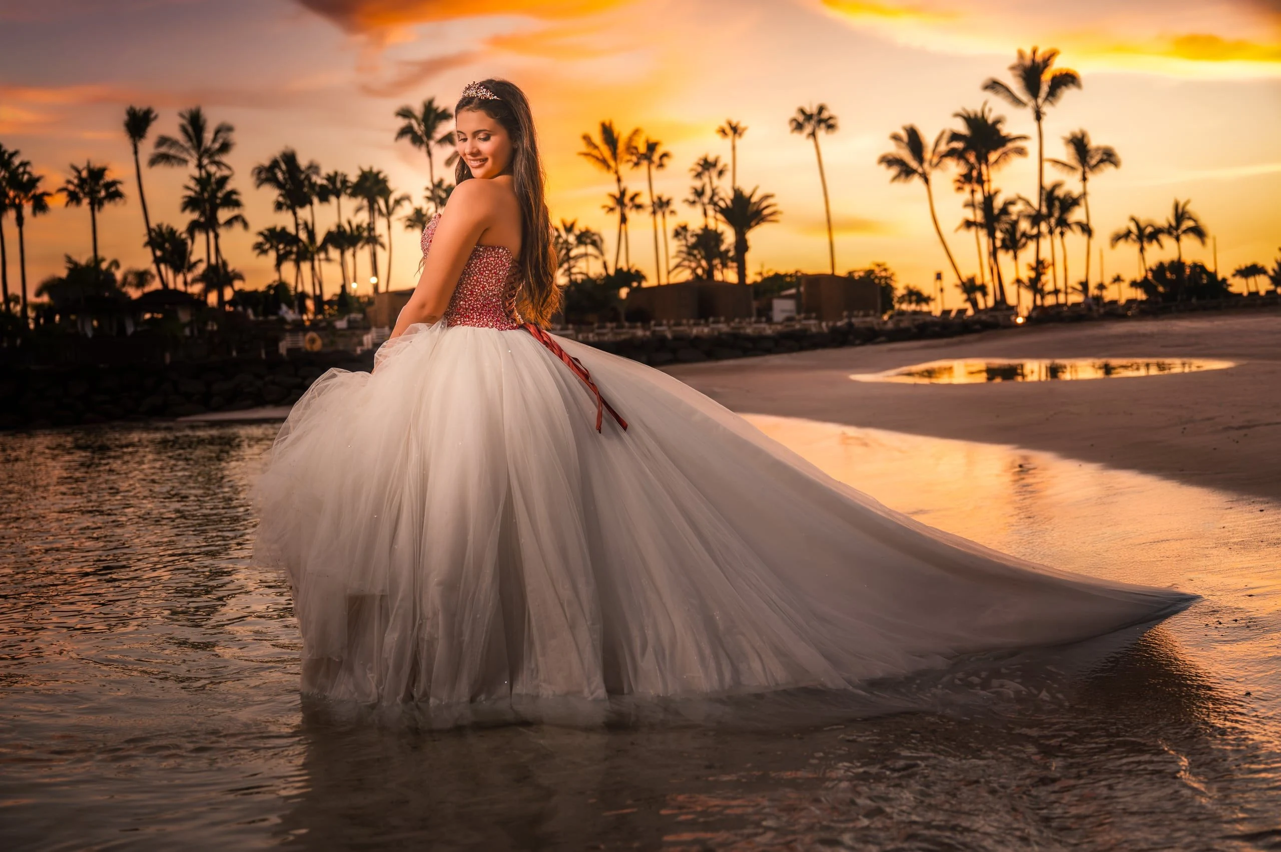 Quinceañera con vestido blanco al atardecer.
