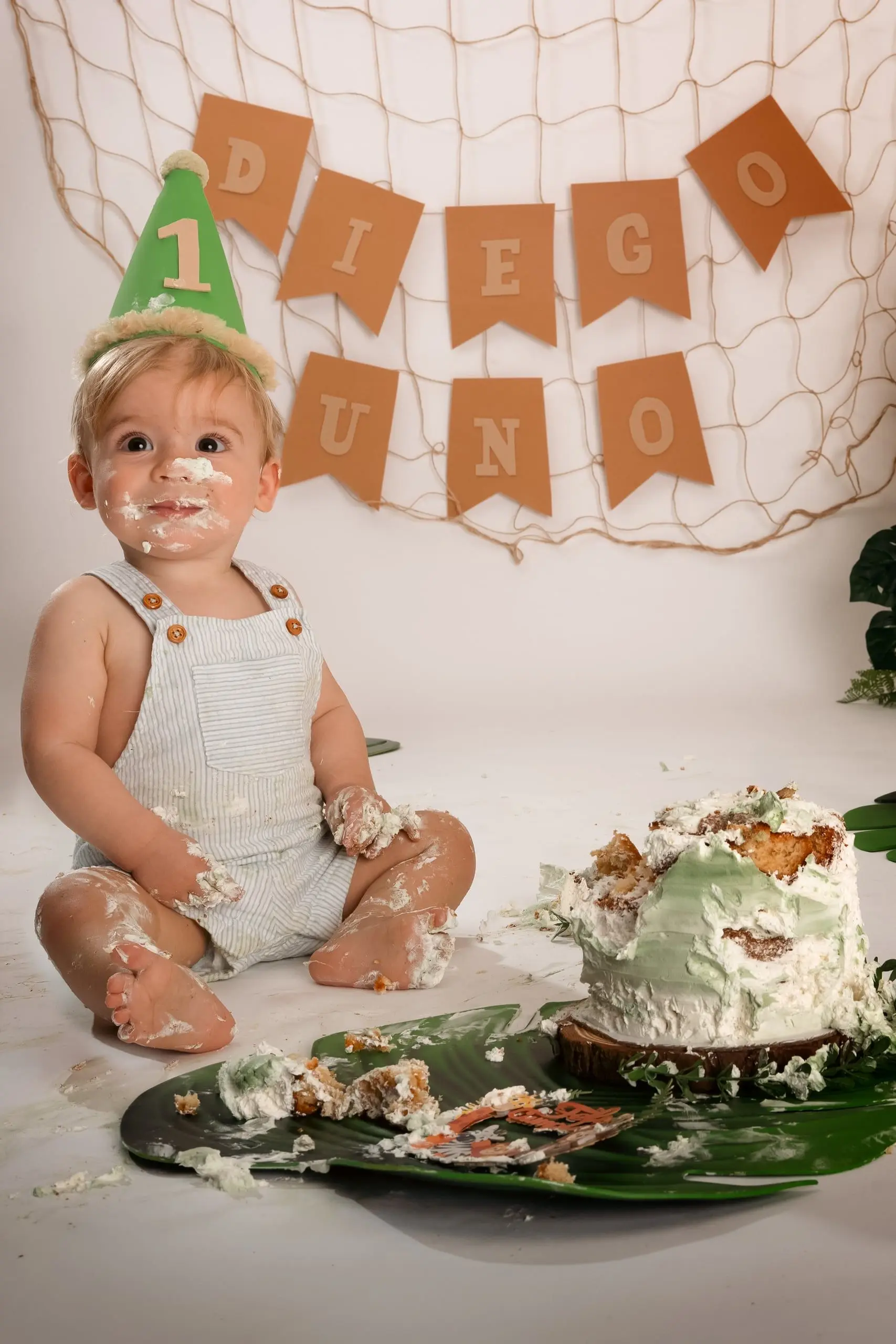 Bebé juega con la tarta en un decorado de cumpleaños.