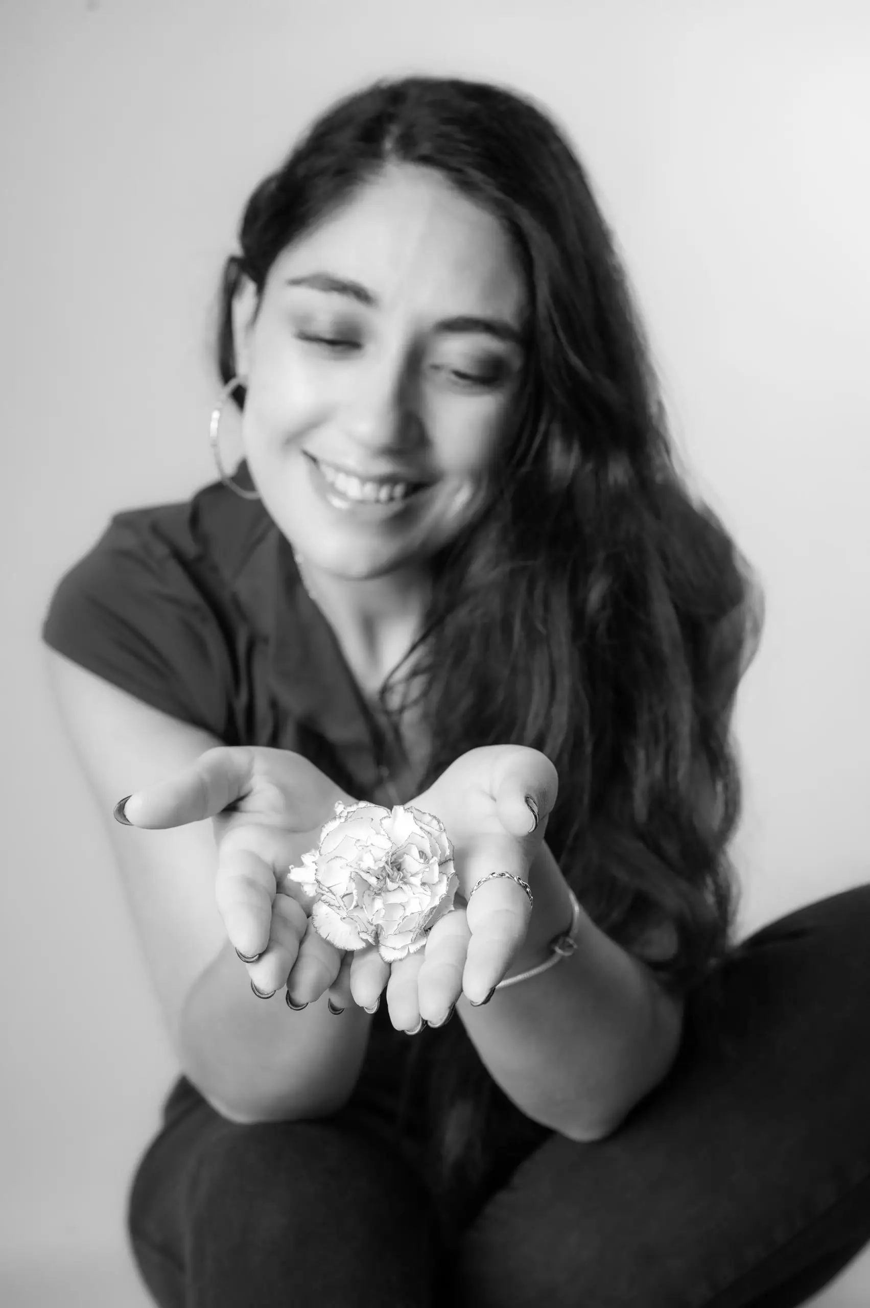 Mujer sonriendo en un retrato en blanco y negro.