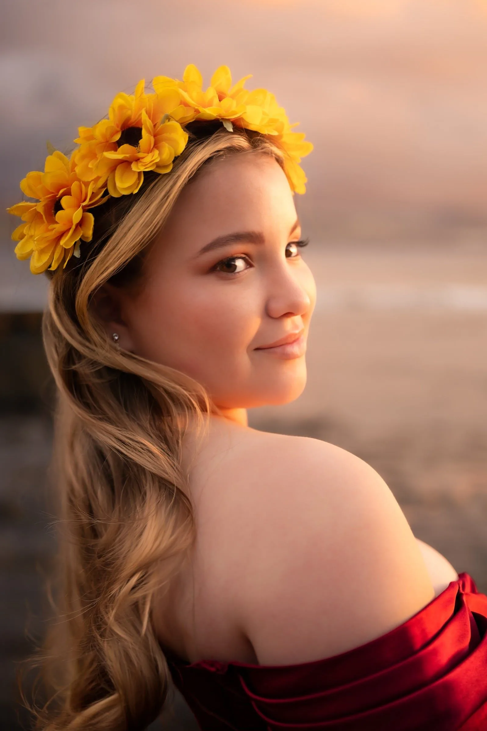 Retrato de quinceañera con flores amarillas en el pelo y luz cálida sobre el rostro.