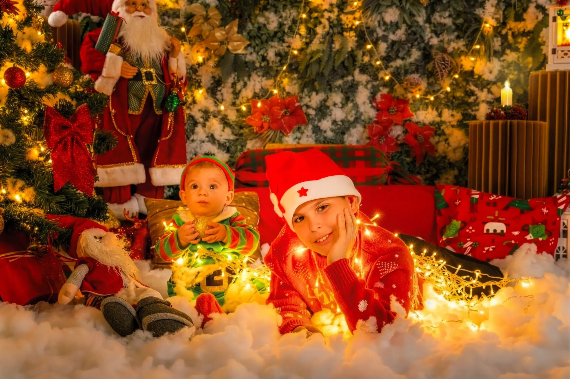 Dos niños con gorros navideños juegan entre pequeñas luces cálidas.