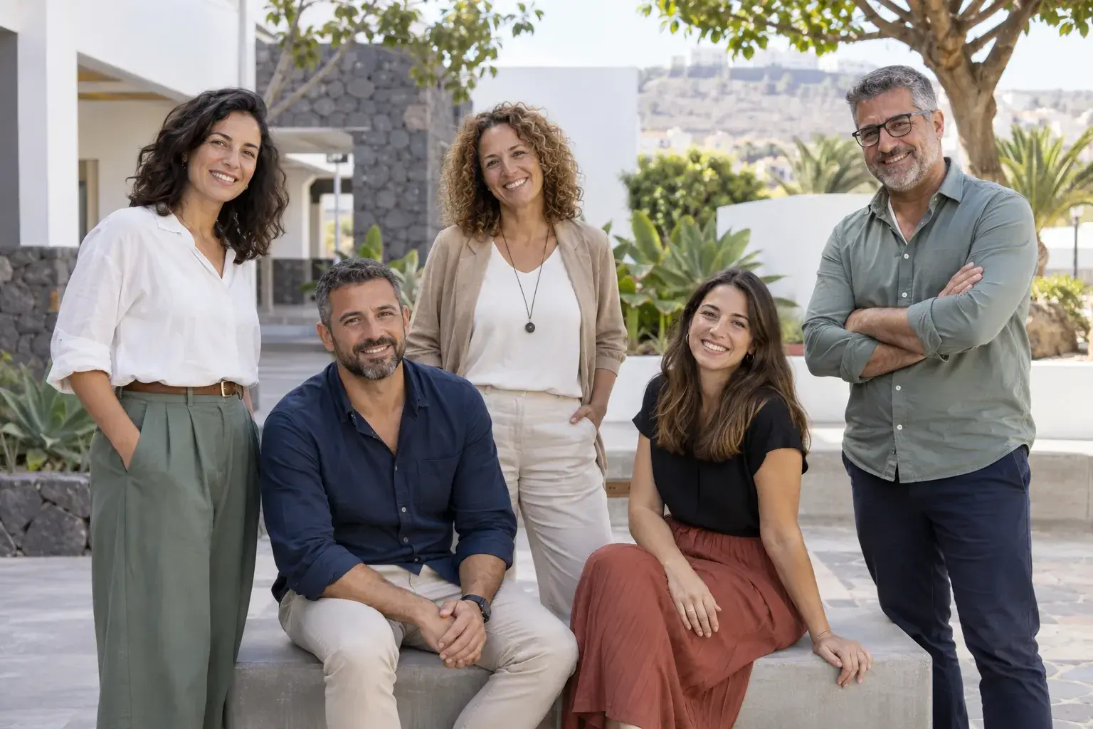 Equipo docente ficticio reunido en un patio escolar luminoso.
