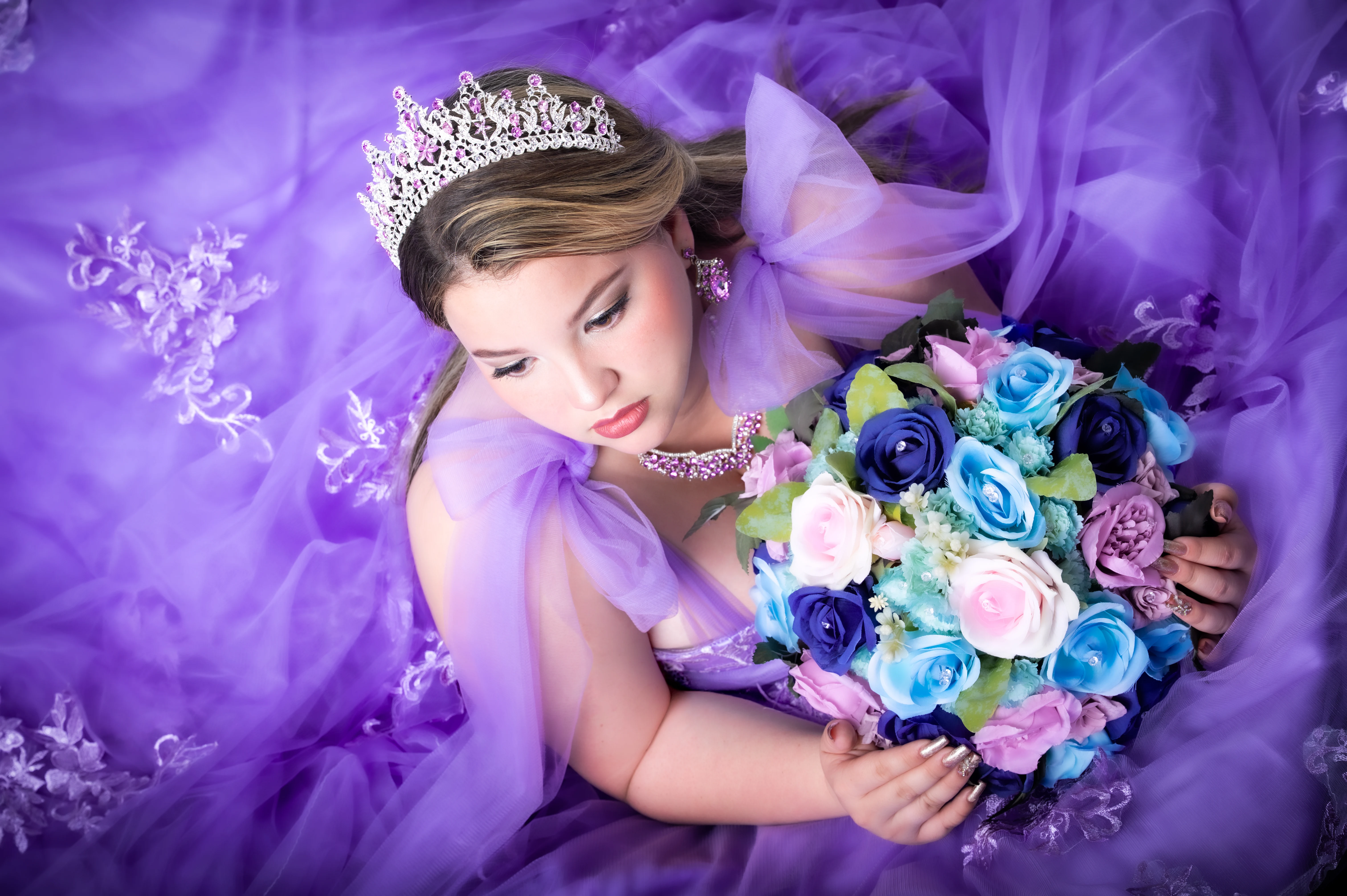 Retrato de quinceañera con vestido lila y un ramo de flores.