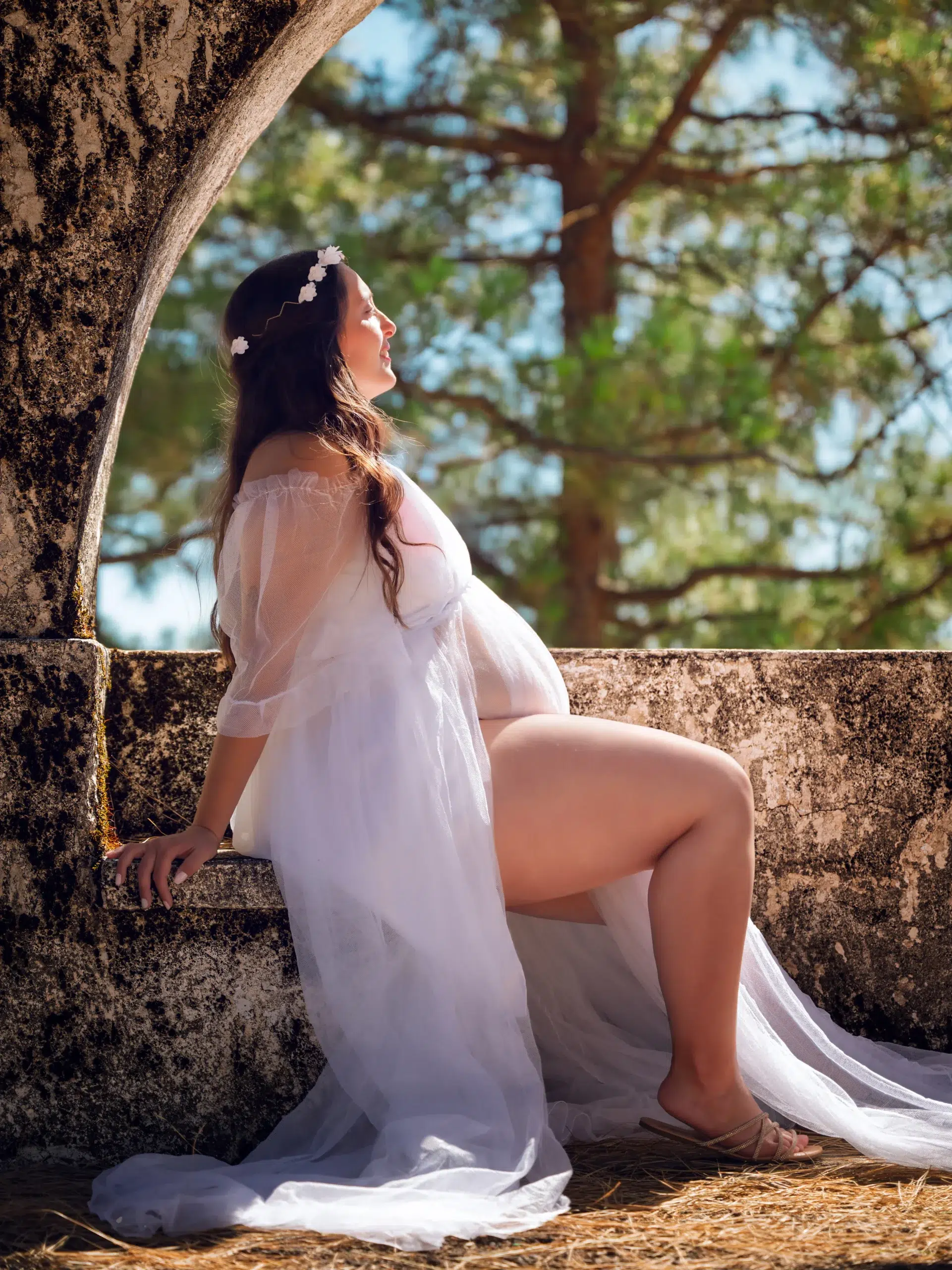 Mujer embarazada con vestido blanco posando en exteriores durante una sesión fotográfica de embarazo en Las Palmas.