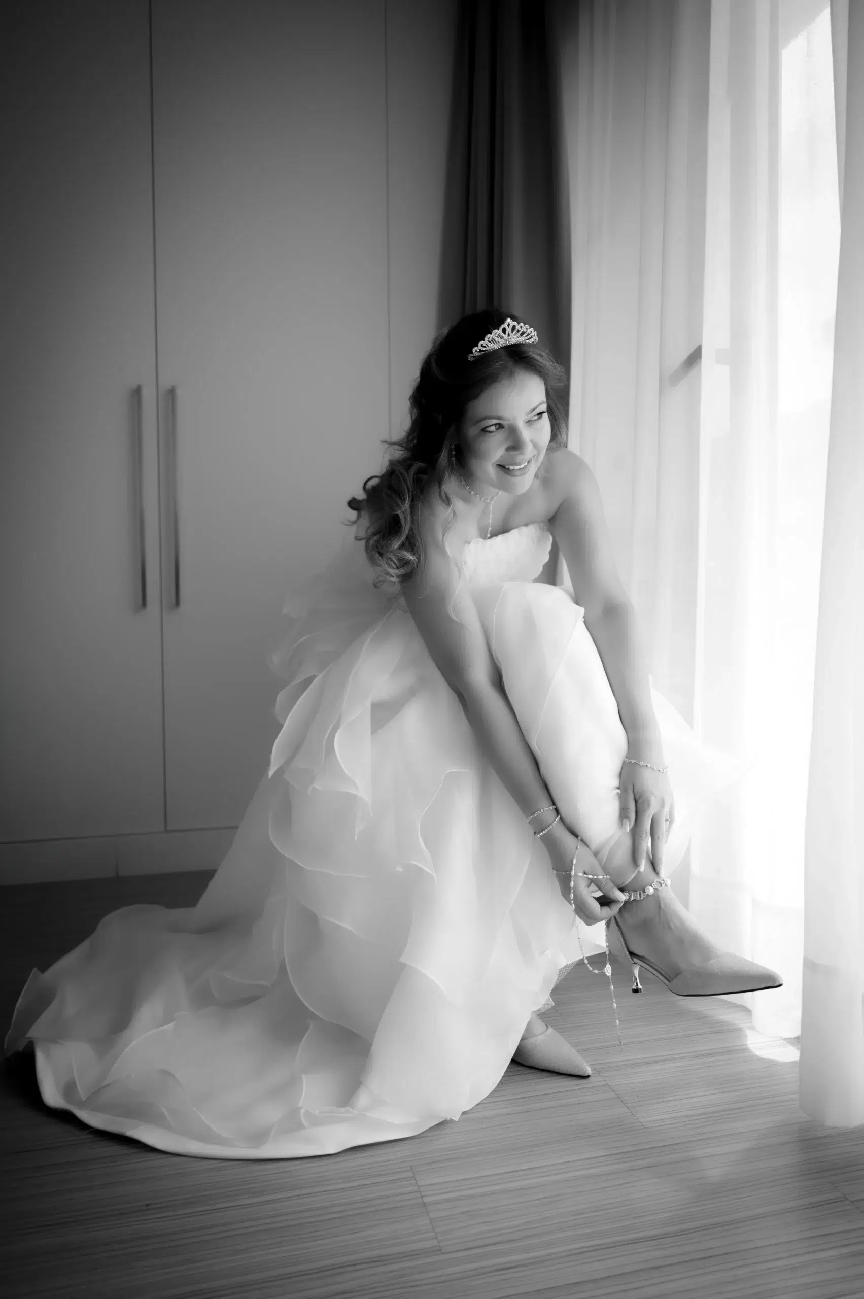 Novia poniéndose los zapatos junto a una ventana durante los preparativos de su boda en Las Palmas de Gran Canaria