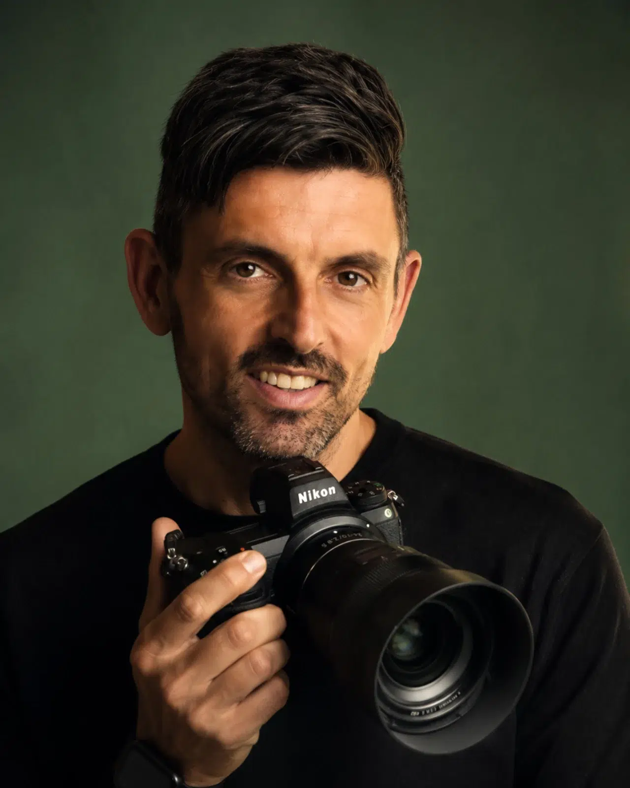 Retrato de Pietro, fotógrafo profesional en Gran Canaria, sosteniendo una cámara