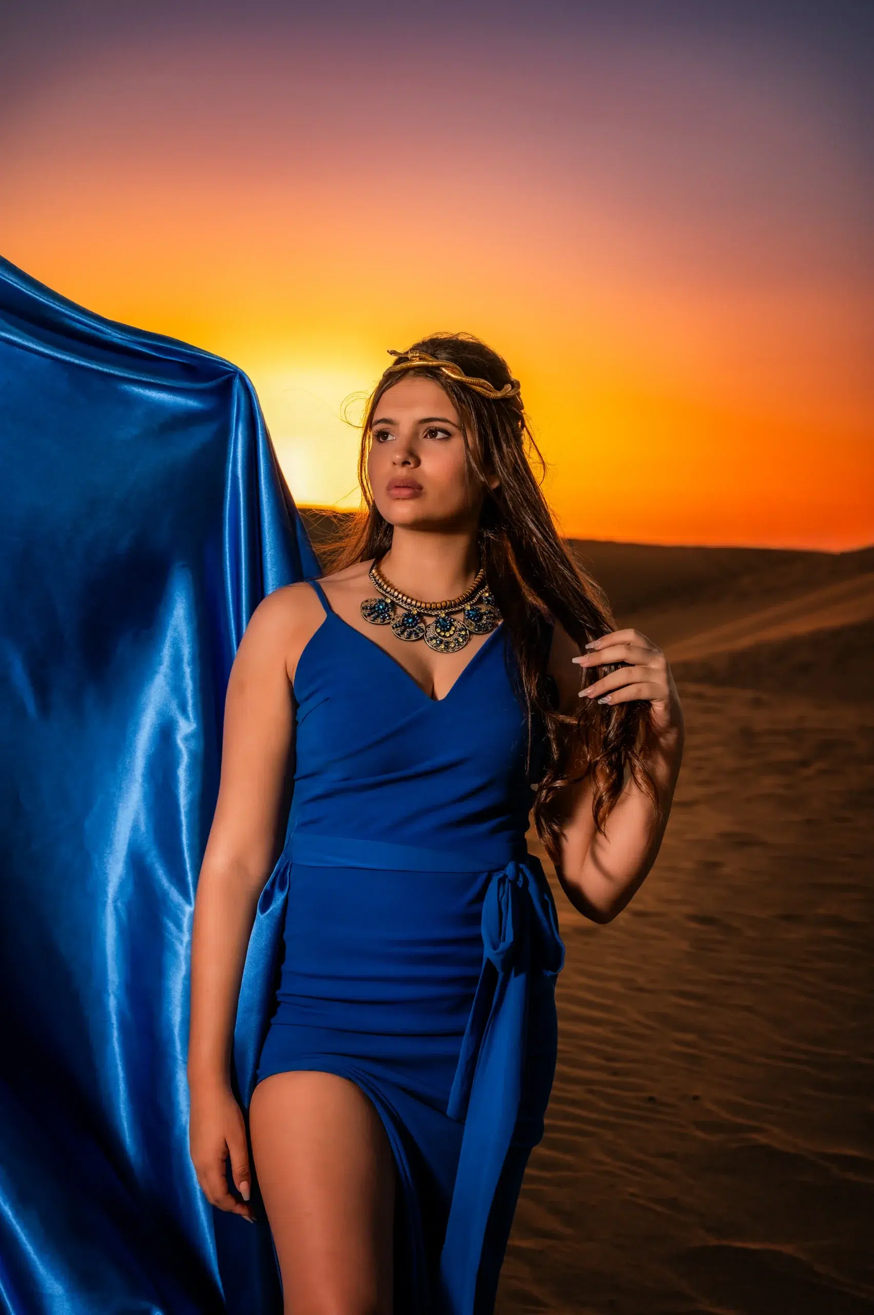 Retrato de una quinceañera con vestido azul mirando hacia un lado durante una sesión en las dunas de Gran Canaria