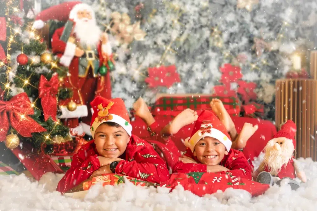 Dos hermanos con pijamas navideños durante una sesión de fotos en MagiArt.