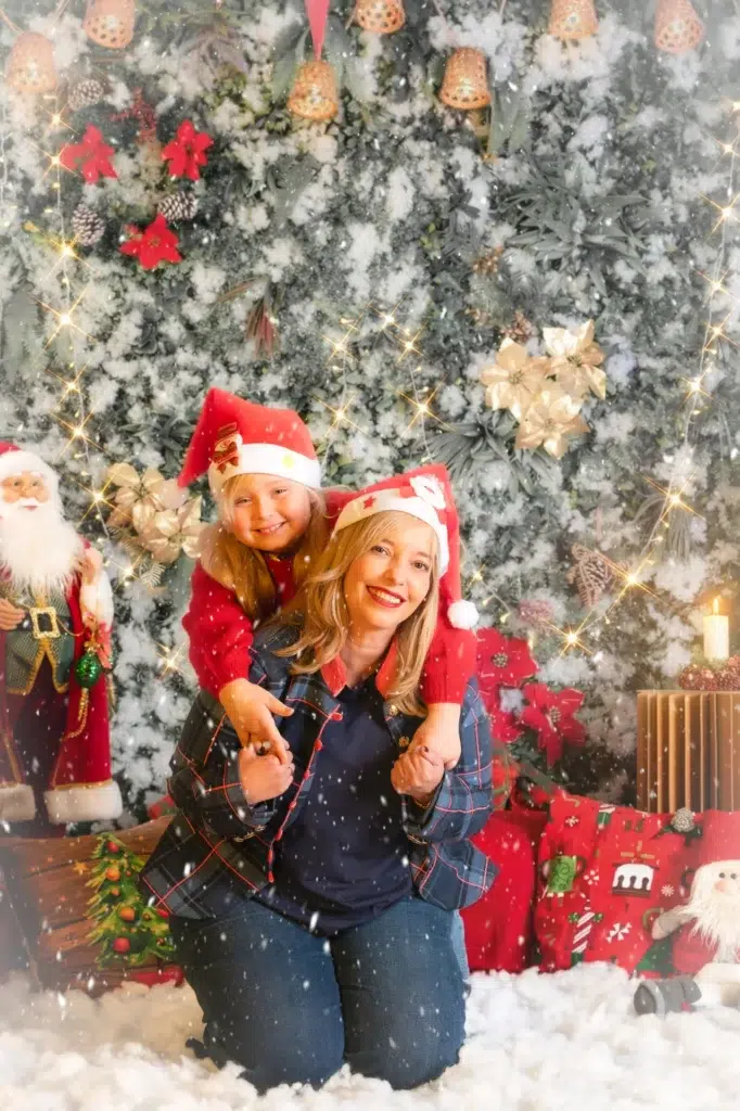 Madre con su hija a caballito durante una sesión de fotos de Navidad.